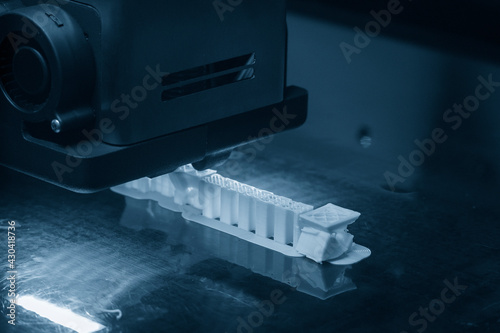 Obraz na płótnie The 3D printer machine print out the sample model prototype. The hi technology Computer Aid Manufacturing process by rapid prototype 3D printer.