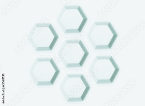 Polygon of hexagons. White plastic hexagonal weighing trays background. Optical illusion. 