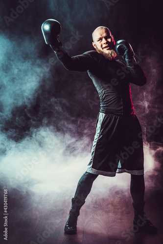 Sportsman boxer fighting on black background with smoke. Boxing