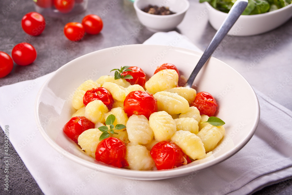 Homemade Italian gnocchi with tomato cherry on the wooden table