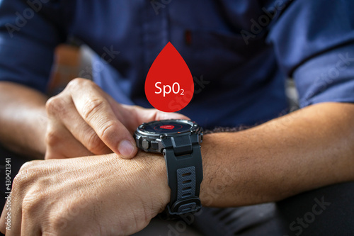 male hand holding wearing smart watch with measure pulse rate and oxygen levels. soft-focus and over light in the background.