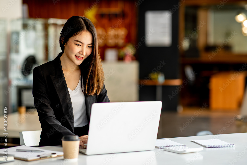Portrait of Accounting businesswoman working on note laptop computer and analyzing real estate investment data, Financial and tax systems concept.