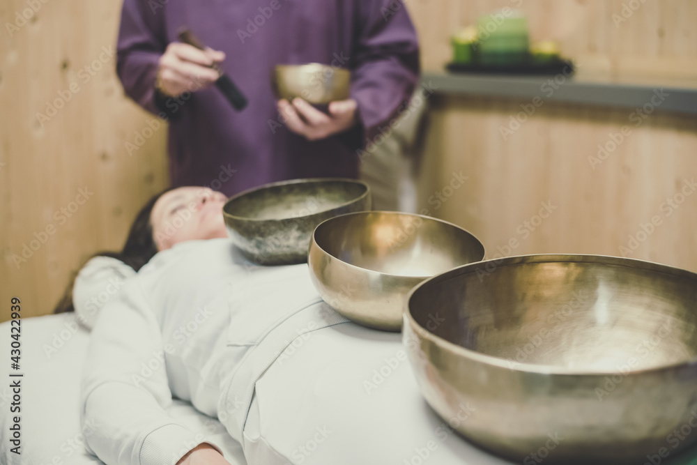 Soft focus view of a woman practicing holistic activities with Tibetan bells. Meditation and mindfulness exercises for calm and clear your mind. Wellness, health, relax, and inner well-being concept. Soft focus view of a woman practicing holistic activities with Tibetan bells. Meditation and mindfulness exercises for calm and clear your mind. Wellness, health, relax, and inner well-being concept.
