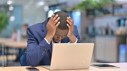 Loss, African Businessman reacting to Failure on Laptop in Office 