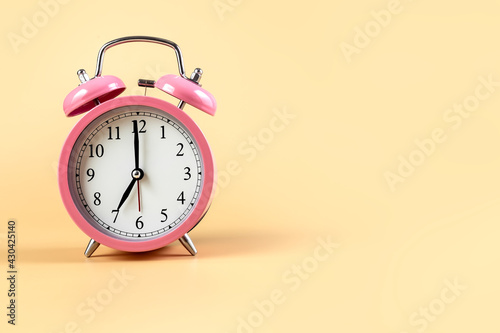 Pink alarm clock on a beige background. Time Concept. Place for your text. Copy space.
