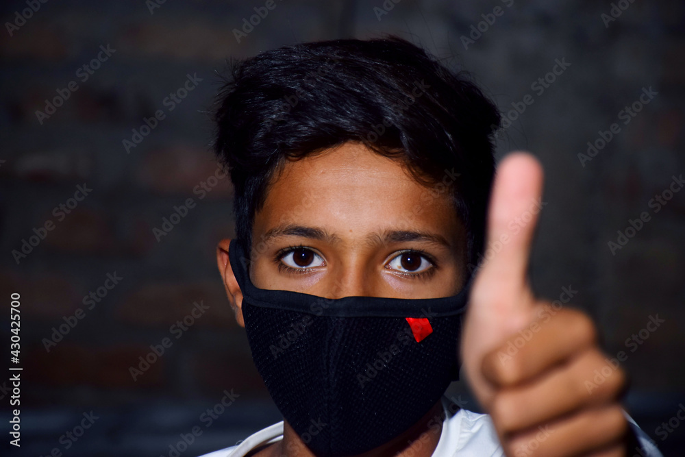 13 years old Asian cute boy wearing protective mask, holding thums up, prevention of Corona virus (Covid -19) and pollution 13 years old Asian cute boy wearing protective mask, holding thums up, prevention of Corona virus (Covid -19) and pollution