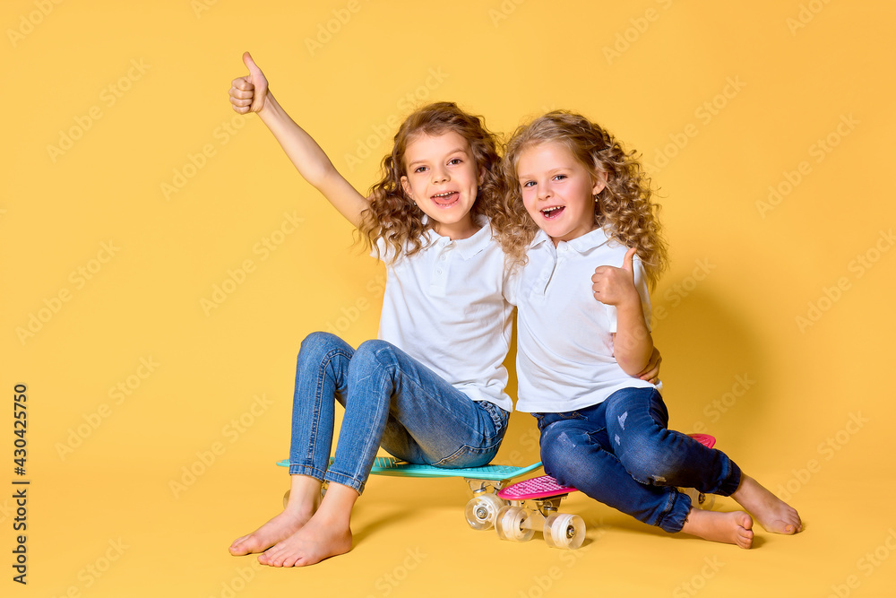 Two Active and happy girls with curly hair having fun with penny Two Active and happy girls with curly hair having fun with penny