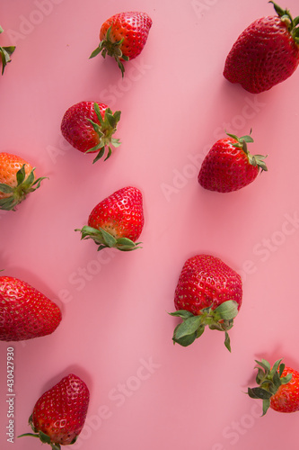 Delicious juicy ripe red strawberries on a pink background. Close-up shot of strawberries on a grater. Berry pattern