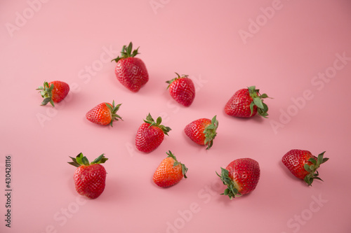 Delicious juicy ripe red strawberries on a pink background. Close-up shot of strawberries on a grater. Berry pattern