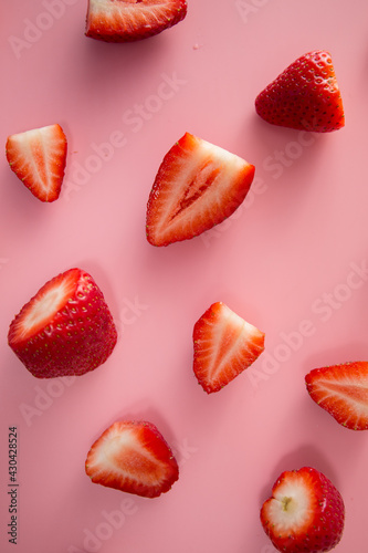 Delicious juicy ripe red strawberries on a pink background. Close-up shot of strawberries on a grater. Berry pattern