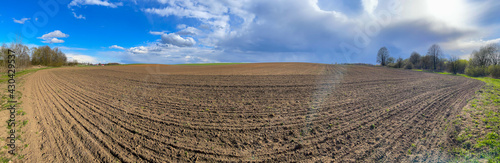Panorama of a prepared plowed field on a sunny day