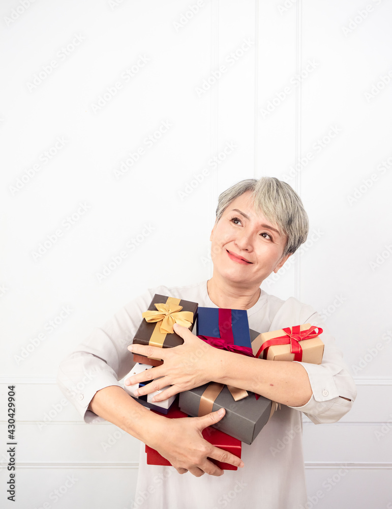 Senior asian woman holding mount of gift boxes, enjoying many best presents. Senior asian woman holding mount of gift boxes, enjoying many best presents.