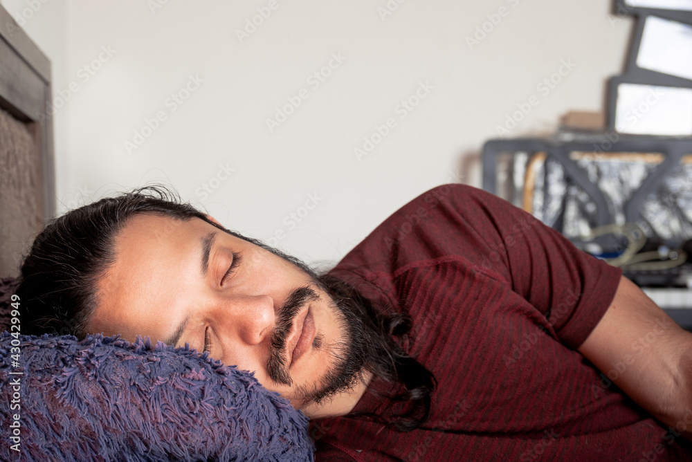 Young latin man sleeping on bed at home. Man taking a nap at home. Young latin man sleeping on bed at home. Man taking a nap at home.