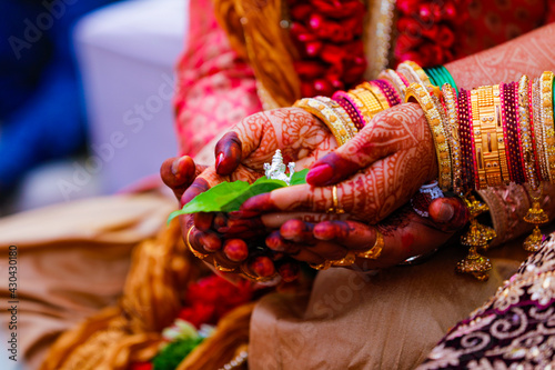groom and bride holding green leaf and lord Ganesha sculpture in hand