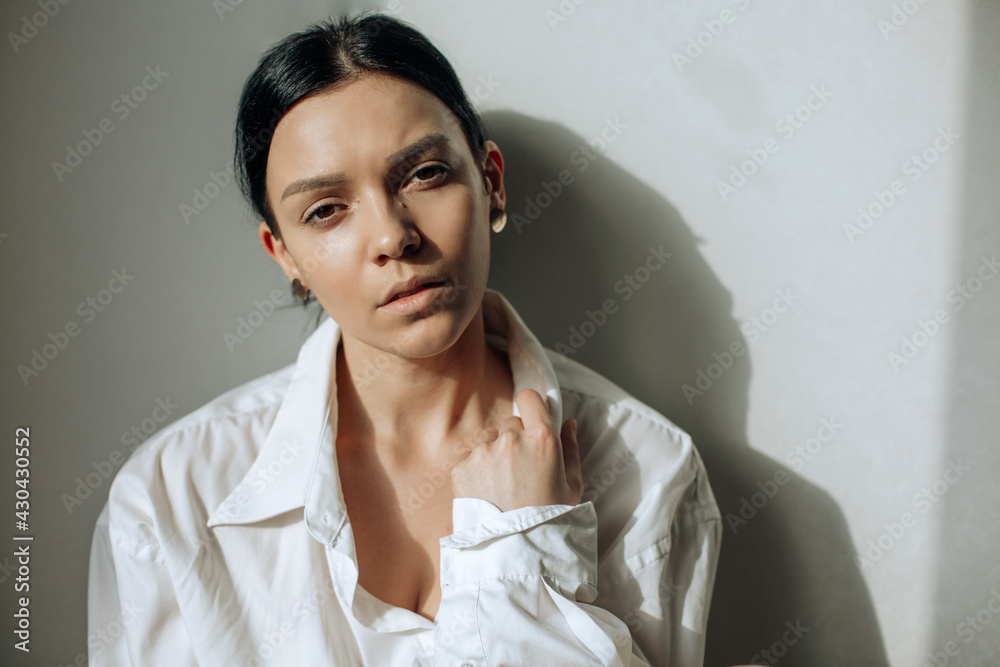 Beautiful face of young adult woman with clean fresh skin on white shirt. Horizontal photo