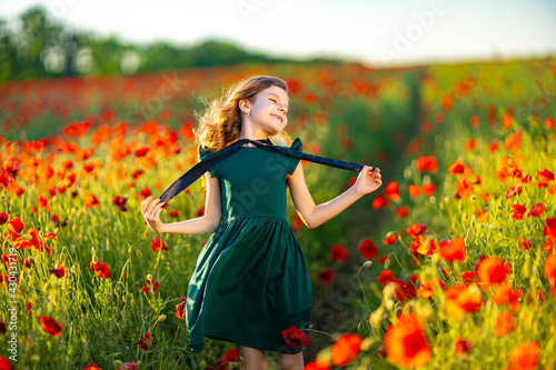 Girl in dress and straw hat outdoor At Poppy Field