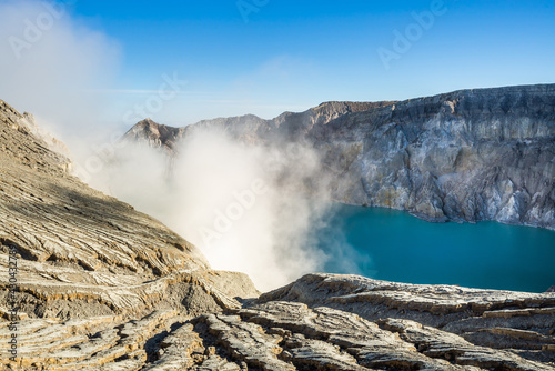 Ijen volcano crater with lake and sulphur mining. Beautiful Landscape mountain and green lake with smoke sulfur in the morning in a Kawah Ijen volcano. Beautiful landmark from East Java, Indonesia © cattyphoto