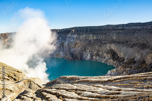 Ijen volcano crater with lake and sulphur mining. Beautiful Landscape mountain and green lake with smoke sulfur in the morning in a Kawah Ijen volcano. Beautiful landmark from East Java, Indonesia