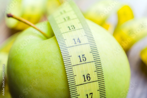 Yellow Measuring Tape Lying On A Green Apple - Life Healthy Concept