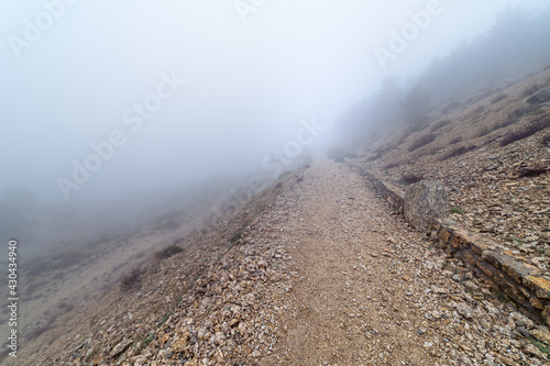 Stone path in the mountain on a day of intense fog and atmosphere of mystery. Morcuera. photo