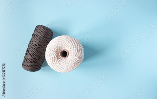 A skein of cotton cord and polyester cord on a blue background, free space.