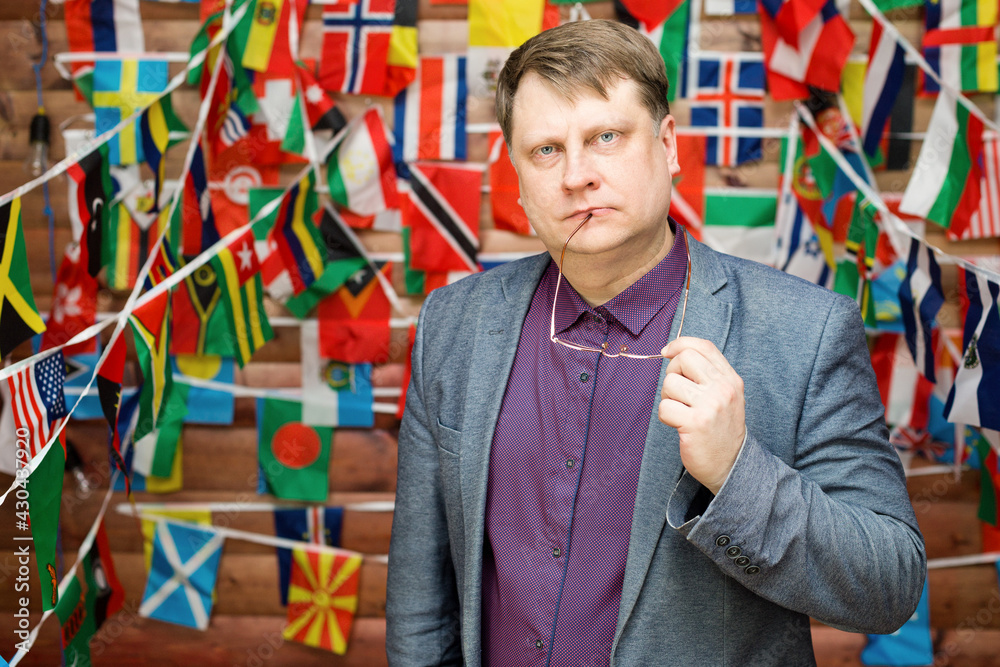 adult man with glasses in his hand against the background of the country flag adult man with glasses in his hand against the background of the country flag
