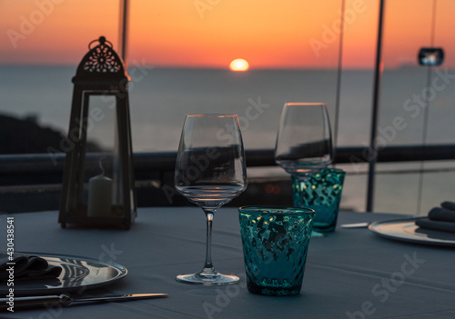 Two wine glasses and glasses served on a sunset background © esherez