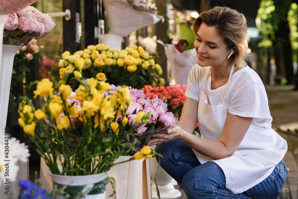 Young woman florist working in her little flower shop