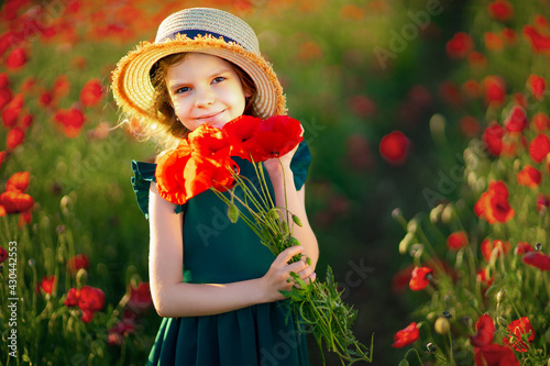 Girl in dress and straw hat outdoor At Poppy Field