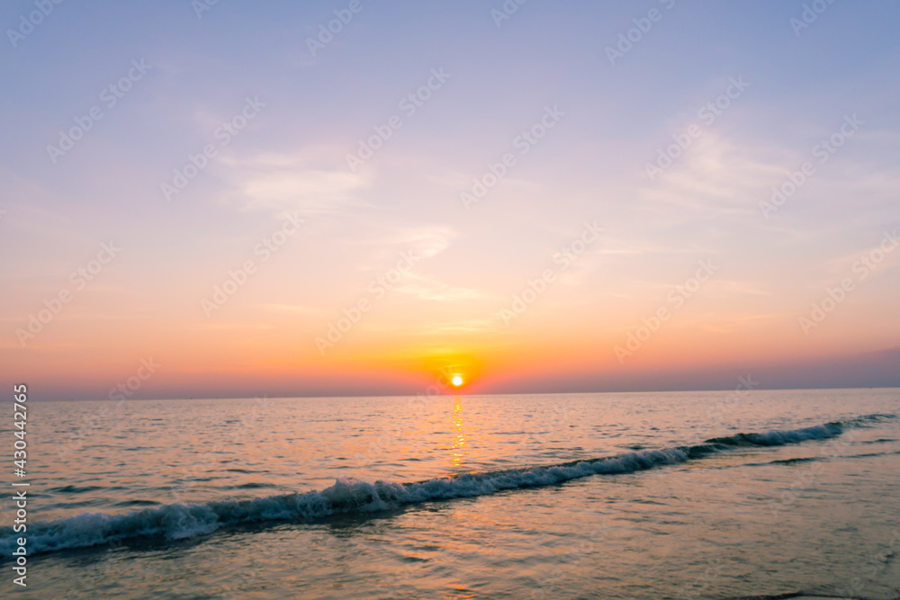 Sunset reflection sea. beautiful sunset behind the clouds and blue sky above the over sea landscape background