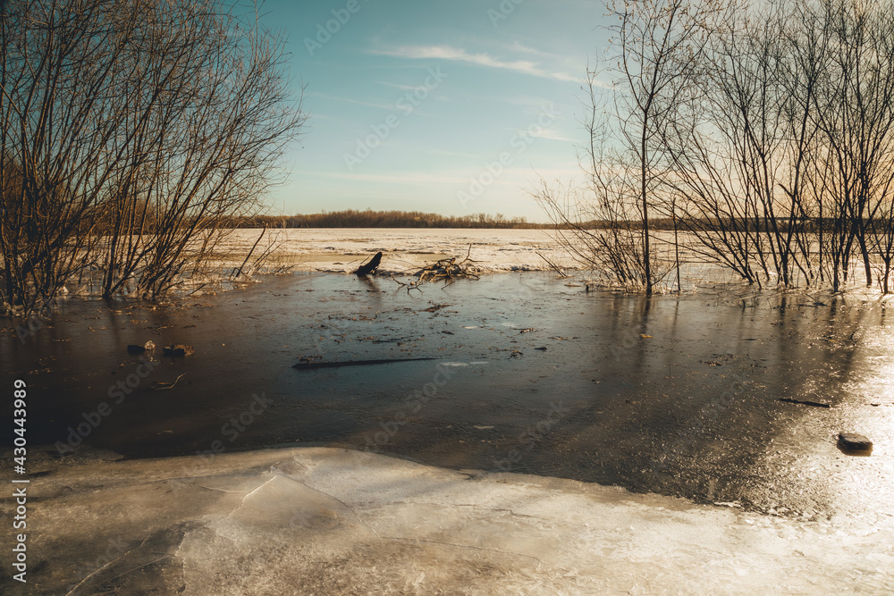 Obraz premium ice crust covers the riverbank on a frosty spring morning at dawn