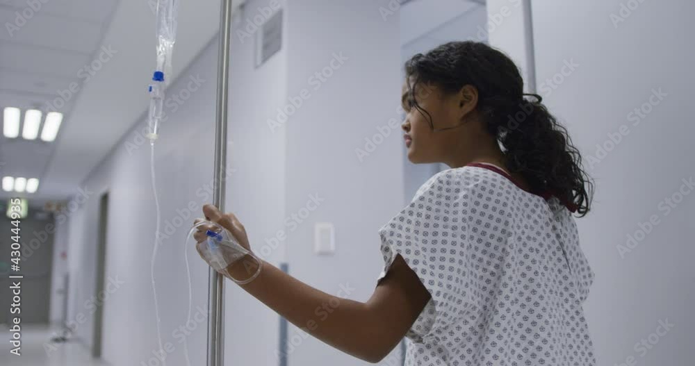 Mixed race girl walking with drip bag in hospital room Mixed race girl walking with drip bag in hospital room