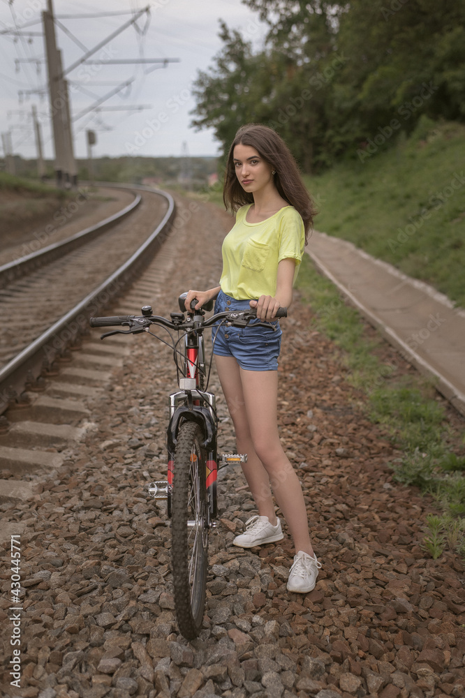 Fototapeta premium A shot of a sporty woman who is riding the bike not far from the city. It's useful for health and at least just interesting. 