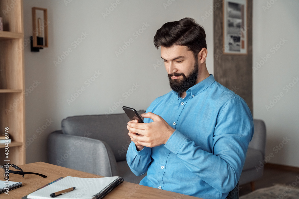 Millennial freelance businessman take break during workday using mobile phone Millennial freelance businessman take break during workday using mobile phone