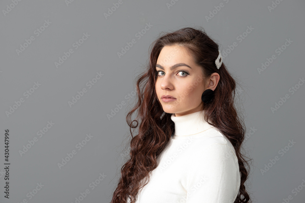portrait of beautiful sensual woman with long curly hair against gray background portrait of beautiful sensual woman with long curly hair against gray background