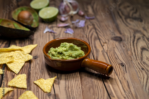 avocado dip flavored with garlic, chili, pepper, and lime juice with corn nachos