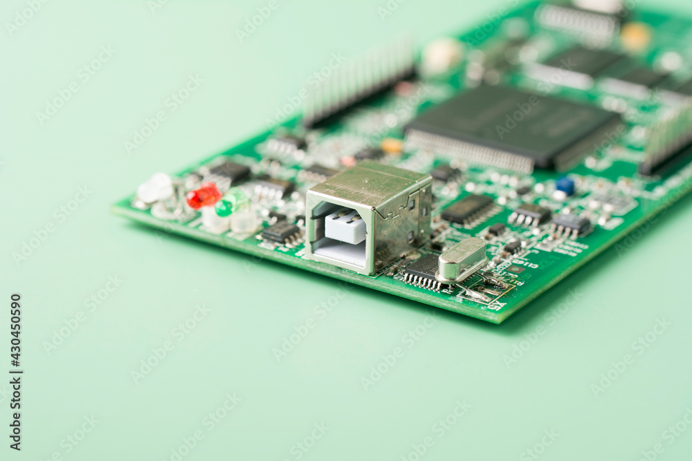 Printed circuit boards PCB with electronic chip components on green background. Minimal industry backdrop. Printed circuit boards PCB with electronic chip components on green background. Minimal industry backdrop.