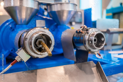 фотографія Close up: blue pet food extruder machine: mixed feed production line at factory, plant, exhibition, trade show