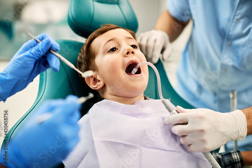 Little boy with mouth wide open during dental check-up at dentist's office. photo