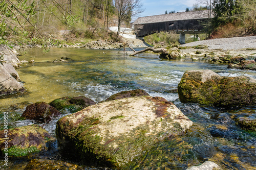 Bilde på lerret Alte gedeckte Holzbrücke über Fluss mit grünem Wasser