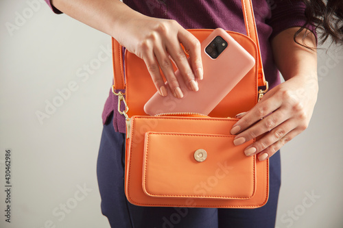 woman holding phone on bag
