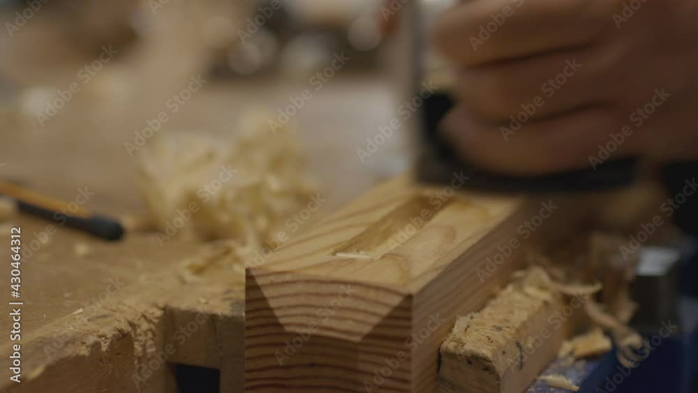 Close up of a Carpenter using a hand plane on his workbench. Woodworking and craftmanship concept Close up of a Carpenter using a hand plane on his workbench. Woodworking and craftmanship concept