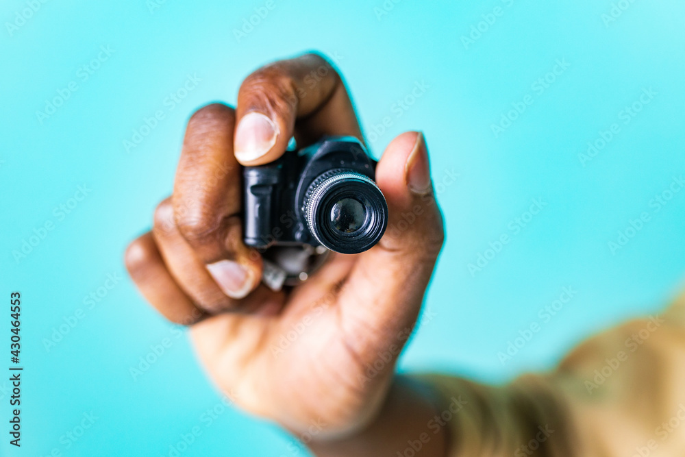 mini camera in hand of african american people in blue studio mini camera in hand of african american people in blue studio