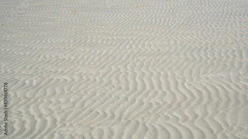 Natural sand pattern on flat sandy beach during low tide.