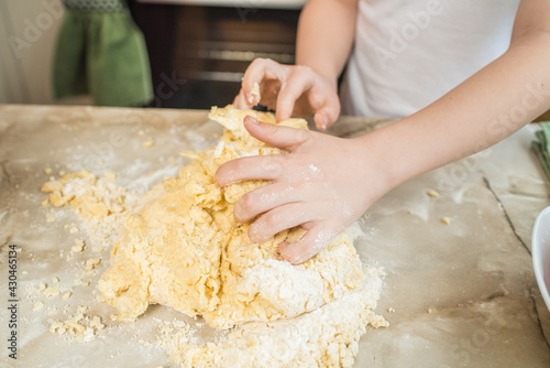Child's hands kneading dough at home in the kitchen. Cooking at home