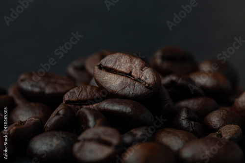 Roasted coffee beans on the old dark wooden background for wallpaper or decor. Shallow depth of field. Selected focuse