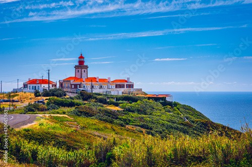 The lighthouse in Cabo da Roca. Cliffs and rocks on the Atlantic ocean coast in Sintra in a beautiful summer day, Portugal. Cabo da Roca, Portugal. Lighthouse and cliffs over Atlantic Ocean. photo