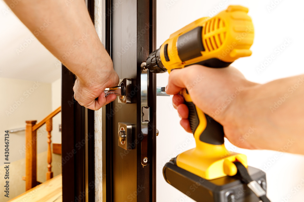 a man repairing a doorknob. Handyman repair the door lock in the room a man repairing a doorknob. Handyman repair the door lock in the room