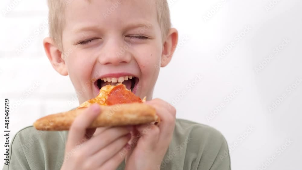 Portrait blonde boy Eating cheese Pizza Smiling close up. Happy Child chewing slice pizza Indoors. Unhealthy junk fast food. Portrait blonde boy Eating cheese Pizza Smiling close up. Happy Child chewing slice pizza Indoors. Unhealthy junk fast food.