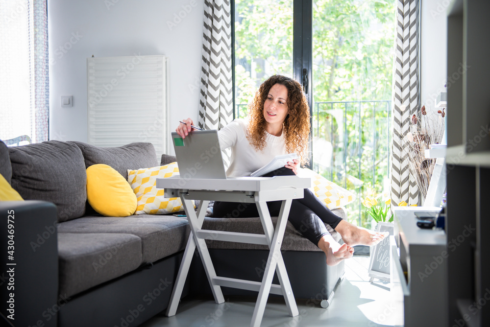 woman sitting on sofa working from home on laptop. girl working with computer woman sitting on sofa working from home on laptop. girl working with computer